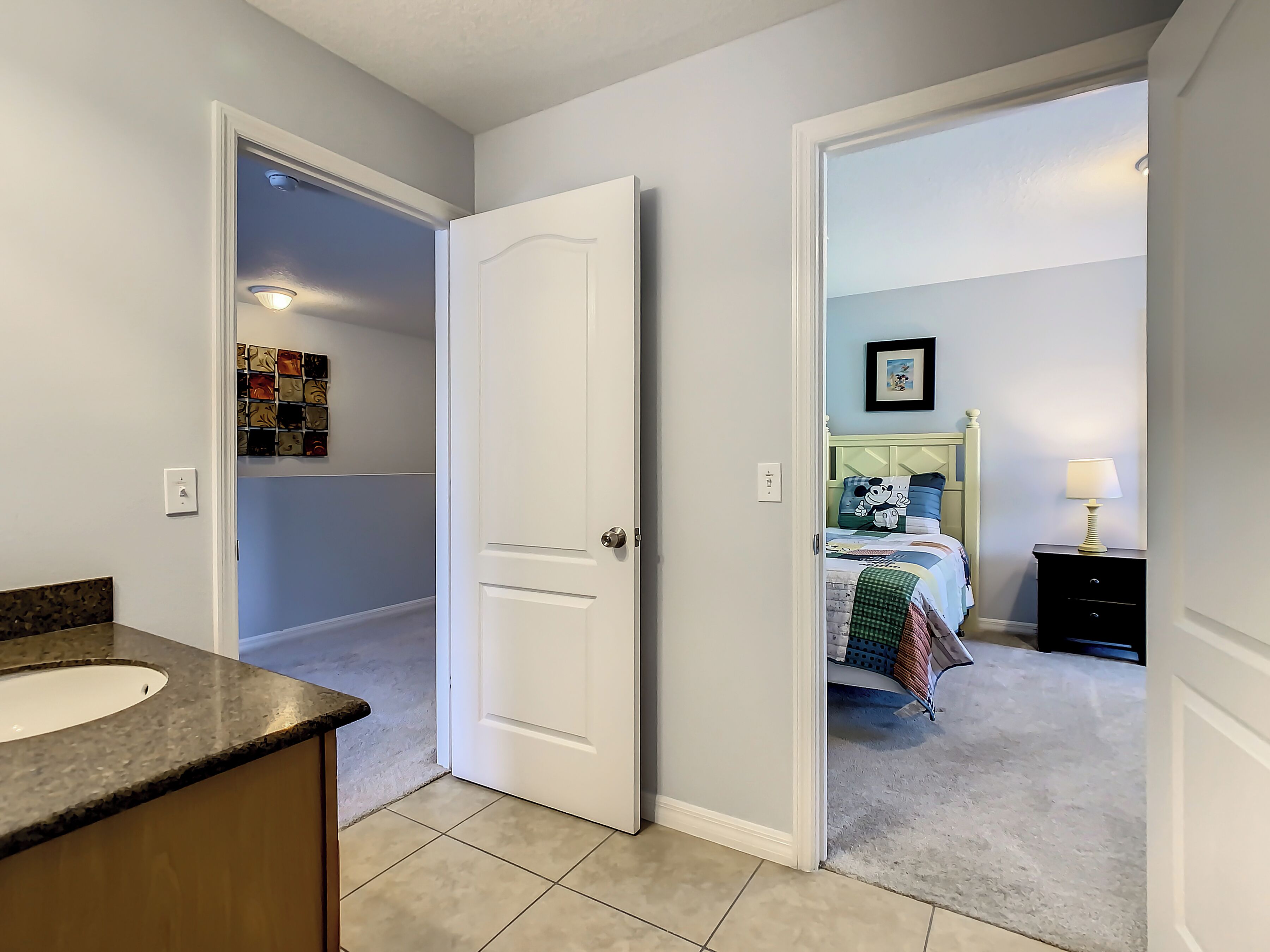 A bedroom with a bed, a nightstand, and a lamp.