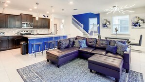 A modern kitchen with dark cabinets, a microwave, and a central island. - A Touch of Blue at Windsor Island Resort (Davenport)