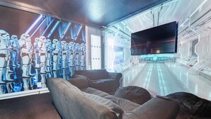 A room with a large window displaying a space-themed mural, a control panel, and a flat-screen TV. - Christopher's Windsor Hills Home (Kissimmee)