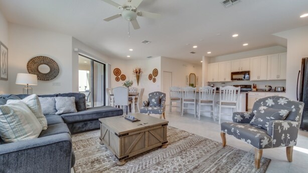 A modern living room with a grey sectional sofa, a patterned rug, and a wooden coffee table. - Beautiful Providence Vacation Home (Davenport)