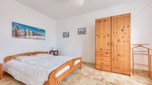 A bedroom with a wooden bed, a wardrobe, and a painting on the wall.