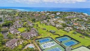 Vista aérea de una zona residencial con casas, espacios verdes y canchas de tenis.