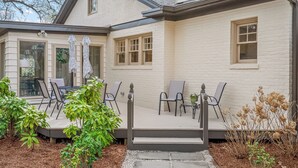 Un patio con mobiliario exterior y un pequeño jardín.