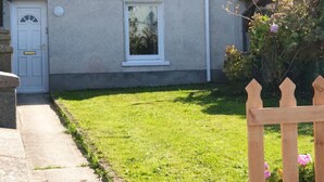 Ein Wohnhaus mit Vorgarten, Holzzaun und Briefkasten.