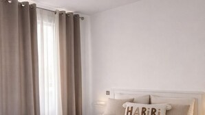 A bedroom with a bed, curtains, a headboard, and a bedside table. - Maison Calme en Bordure de Forêt (Le Perray-en-Yvelines)