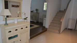A staircase leading to a landing with a mirror, a cabinet with drawers, and a welcome sign. - Faïza  - Four Bedroom Villa, Sleeps 8 (Roquebrune-sur-Argens)