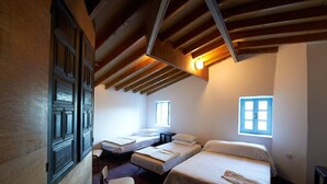 A room with three beds, wooden beams on the ceiling, and two windows. - AMPLE PLACES Monadiko House
Traditional house in the center of Lefkara village (Pano Lefkara)