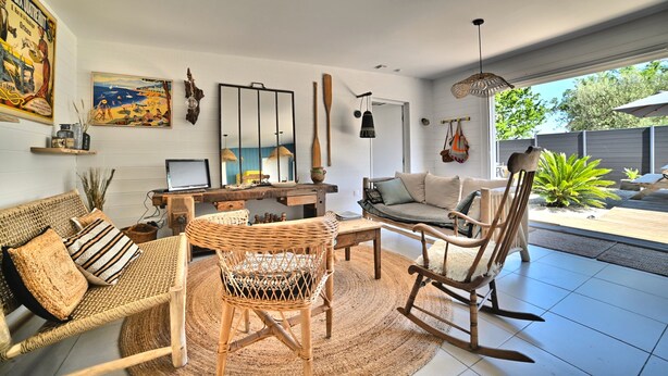 A spacious living area with a sofa, chairs, a dining table, and a large window. - Casa Marcel, 4 Chambres, 4 Sdb, Décoration Bohème, au Calme Dans la Pinède (La Tremblade)