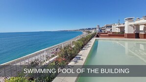 Une piscine située à côté d’une plage, offrant une vue dégagée sur l’océan.