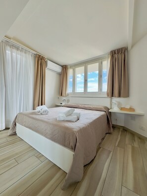 A bedroom with a bed, a nightstand, a window, and curtains. - Ginevra Apartment in Rome, un Superattico con Splendida Terrazza e Vista su Roma (Roma)