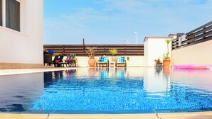 A swimming pool with lounge chairs and potted plants. - Great 3 bedroom villa, with private pool, in the best location in Protaras (Protaras)