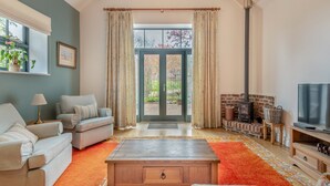 A living room with a sofa, a coffee table, a TV, and a fireplace. - 1 bedroom accommodation in Broad Chalke (Broad Chalke)