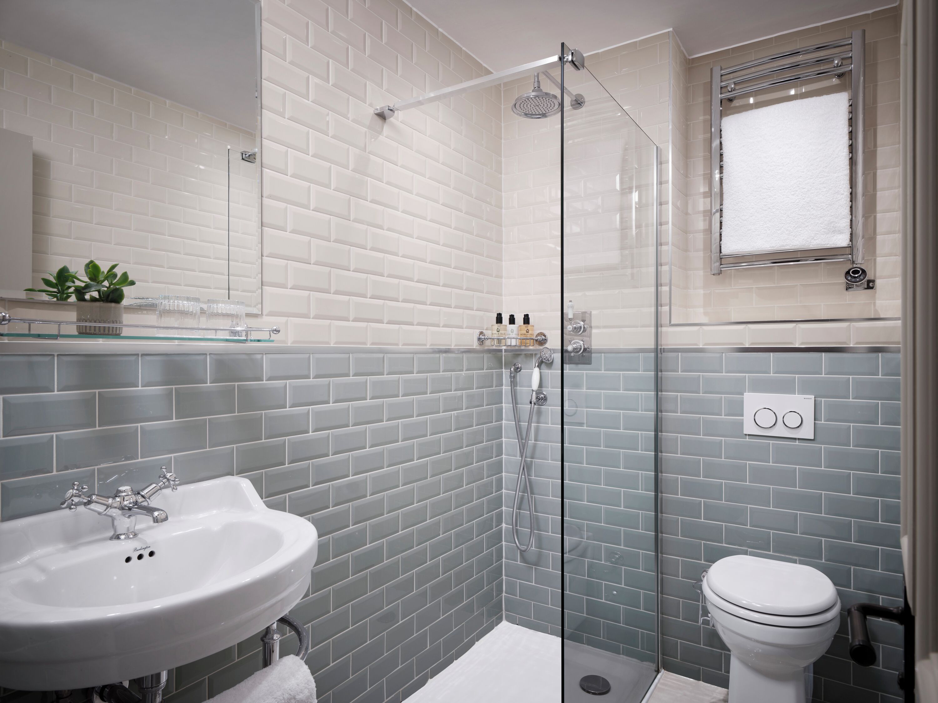 A modern bathroom with a glass-enclosed shower, a white sink, and a toilet.