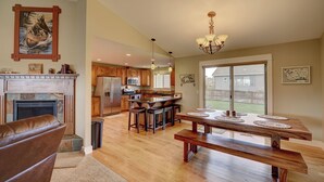 A spacious kitchen with wooden cabinets, a central island, and a dining area with a bench. - A Cozy house in the heart of Gallatin Valley.  (Bozeman)