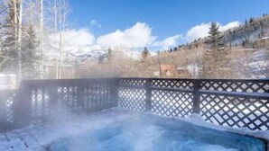 A hot tub in a snowy outdoor setting with a wooden fence and mountains in the background. - Misty Maiden Vista (Telluride)