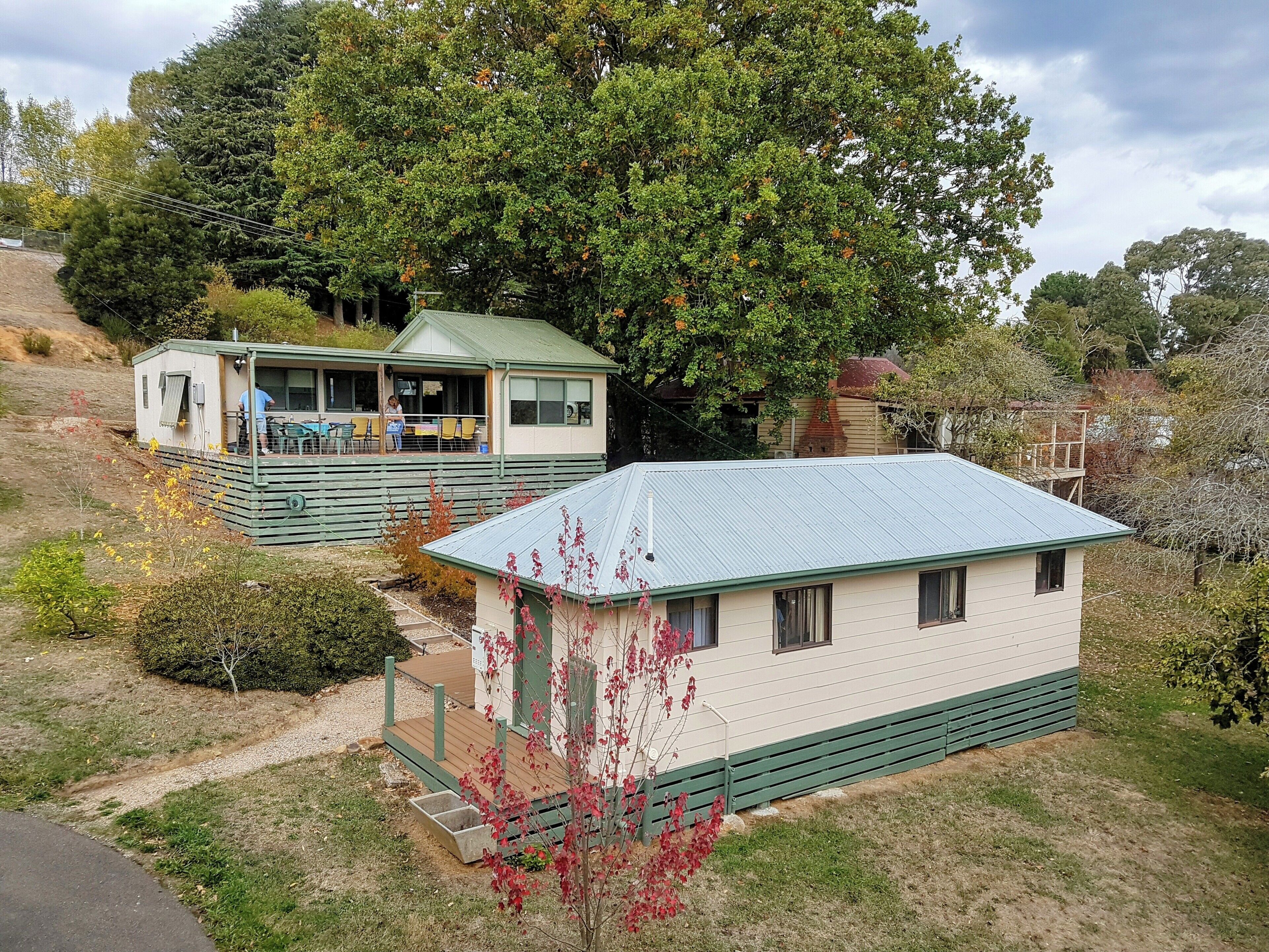 A small, single-story house with a green roof and a porch.