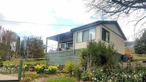 A modern house with a balcony, surrounded by a garden with various plants and flowers. - Oak Cottage - Daylesford - 200m from everything (Daylesford)