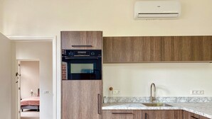 A modern kitchen with wooden cabinets, a built-in oven, and a marble countertop. - Stylish Apartment in Centre of Maastricht (Maastricht)
