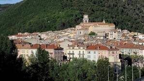 A town with historic buildings and a prominent clock tower. - Charmant Studio vue Montagne Proche Ville et Thermes (Digne-les-Bains)