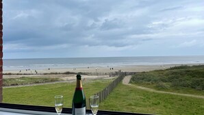 A bottle of Boizel champagne and two glasses on a table with a view of the beach and ocean. - Face MER Pieds Dans L'eau Duplex 4 Chambres 150 M2 8-12 Personnes, Parking ,wifi (Berck)
