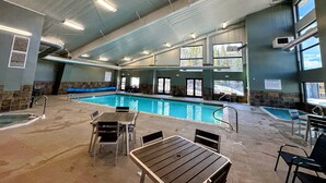 Una piscina interior con varias pistas de natación, zonas de estar y una sección cubierta.