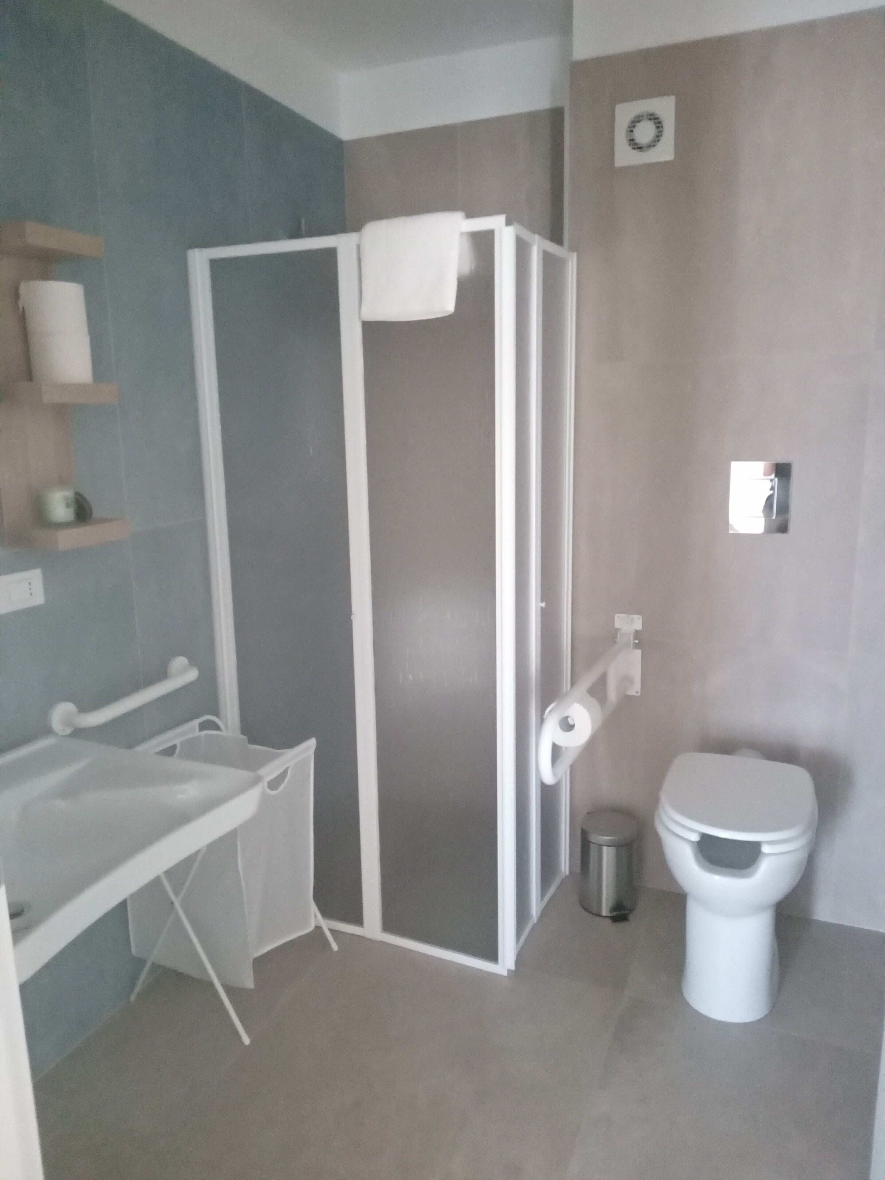 A modern bathroom with a shower enclosure, a toilet, and a sink.