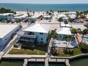 A coastal hotel with multiple buildings, a swimming pool, and a beach view.