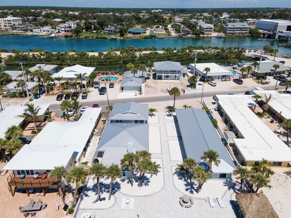 An aerial view of a coastal area with buildings, a marina, and a swimming pool.