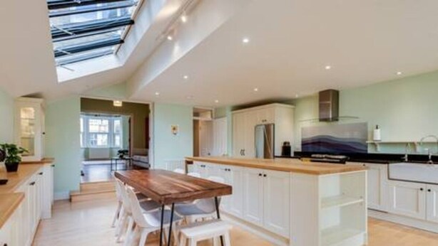 A modern kitchen with a wooden island, white cabinets, and a skylight. - Summertown 4-BR Family Home - Bright & Spacious (Oxford)