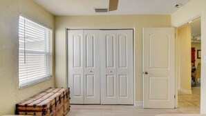 Une pièce avec une grande armoire blanche, une commode en bois et un lit.