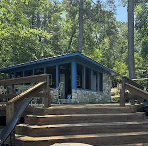 Eine Holzhütte mit Steinfundament, einer Holzdiele und einem blauen Dach.