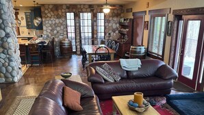 A spacious living area with leather sofas, a coffee table, and a dining table.