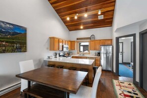 Une cuisine moderne avec des meubles en bois, un îlot central et un réfrigérateur en acier inoxydable.