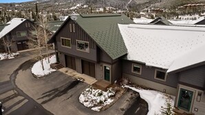 A two-story building with a green roof and a snow-covered ground. - Incredible Ski-Access: 3 Bed Chalet with HotTub (Big Sky)
