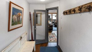 A hallway with a wooden door, a framed picture on the wall, and a rustic wall decor. - Incredible Ski-Access: 3 Bed Chalet with HotTub (Big Sky)