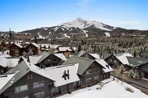 A residential area with snow-covered houses and a mountain in the background. - Incredible Ski-Access: 3 Bed Chalet with HotTub (Big Sky)