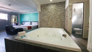 Een moderne badkamer met een ruime badkuip, een douchegedeelte en een apart toilet.