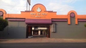 De ingang van Motel Real La Viga, met een opvallend bord boven de ingang.