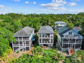 A coastal property with multiple two-story houses featuring balconies and a view of the ocean. - Shuck Yeah - Brand New, Panoramic Marsh and Golf Views, Golf cart included 92 Davis Love (Fripp Island)