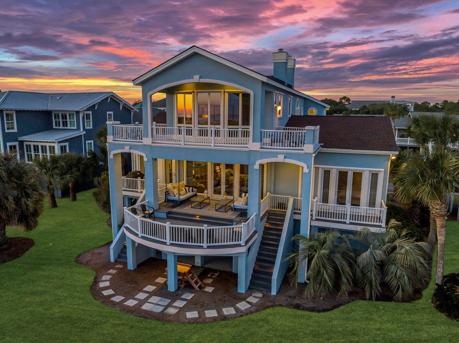 Une maison à deux étages dotée d’un balcon, d’une terrasse couverte et d’une pelouse bien entretenue.