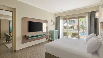 A hotel room with a large bed, a flat-screen TV mounted on the wall, a desk with a chair, and a view of the pool area.
