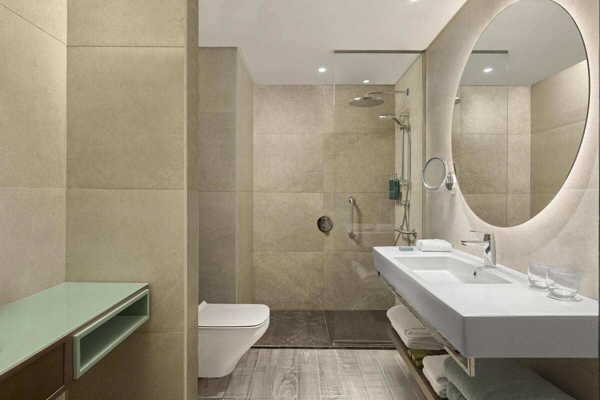 A modern bathroom with a shower, toilet, and sink.