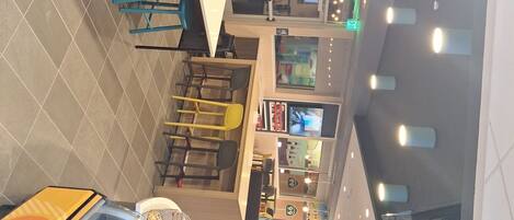 A spacious indoor area with multiple seating arrangements, a refrigerated display case, and a variety of food and beverage options.