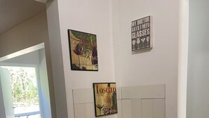 A hallway with a trash can, a door, and two wall-mounted signs.