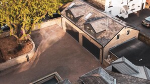 A residential area with a garage, a driveway, and a tree. - Annex, 2 Bed, Sleeps 4, Parking (Ossett)
