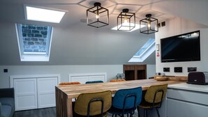 A modern kitchen with a wooden island, bar stools, and pendant lighting. - Annex, 2 Bed, Sleeps 4, Parking (Ossett)