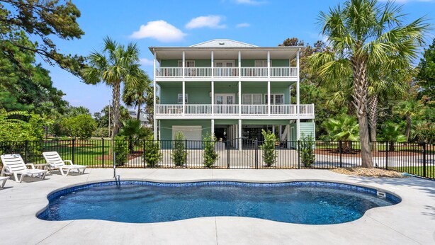 A two-story building with a swimming pool in front. - Indulge in the epitome of coastal living with Celtic Dream-pool (North Myrtle Beach)