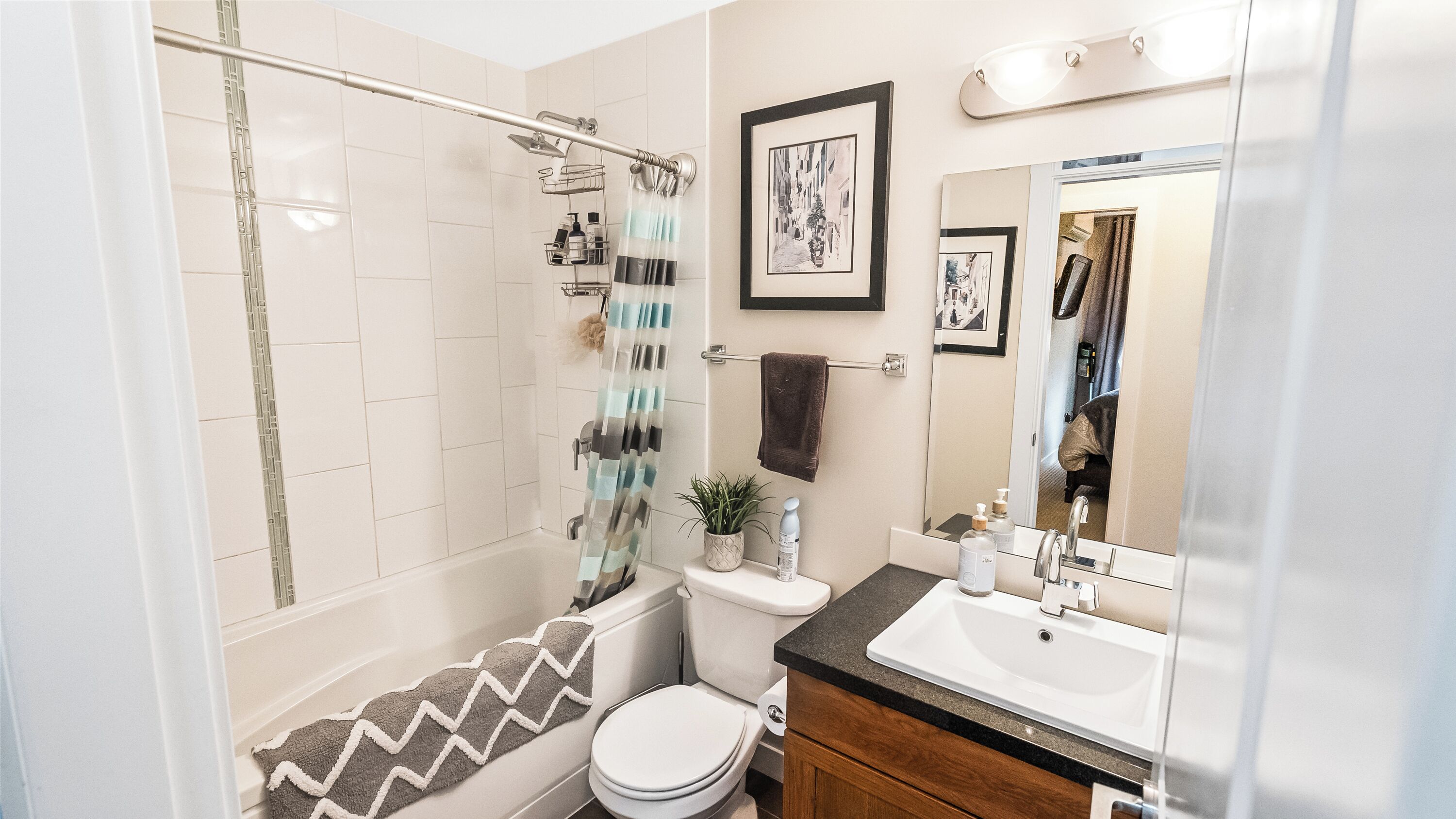 A modern bathroom with a shower, toilet, sink, and vanity.