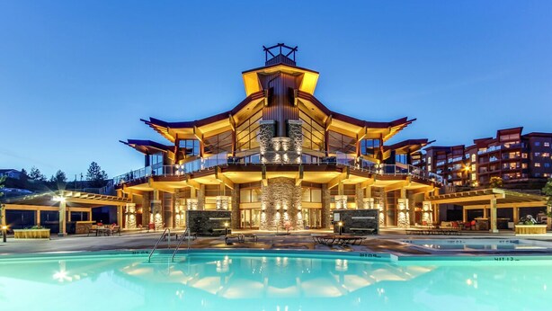 A multi-story hotel with a pool in front. - Top Floor Lake View Condo at Copper Sky (West Kelowna)