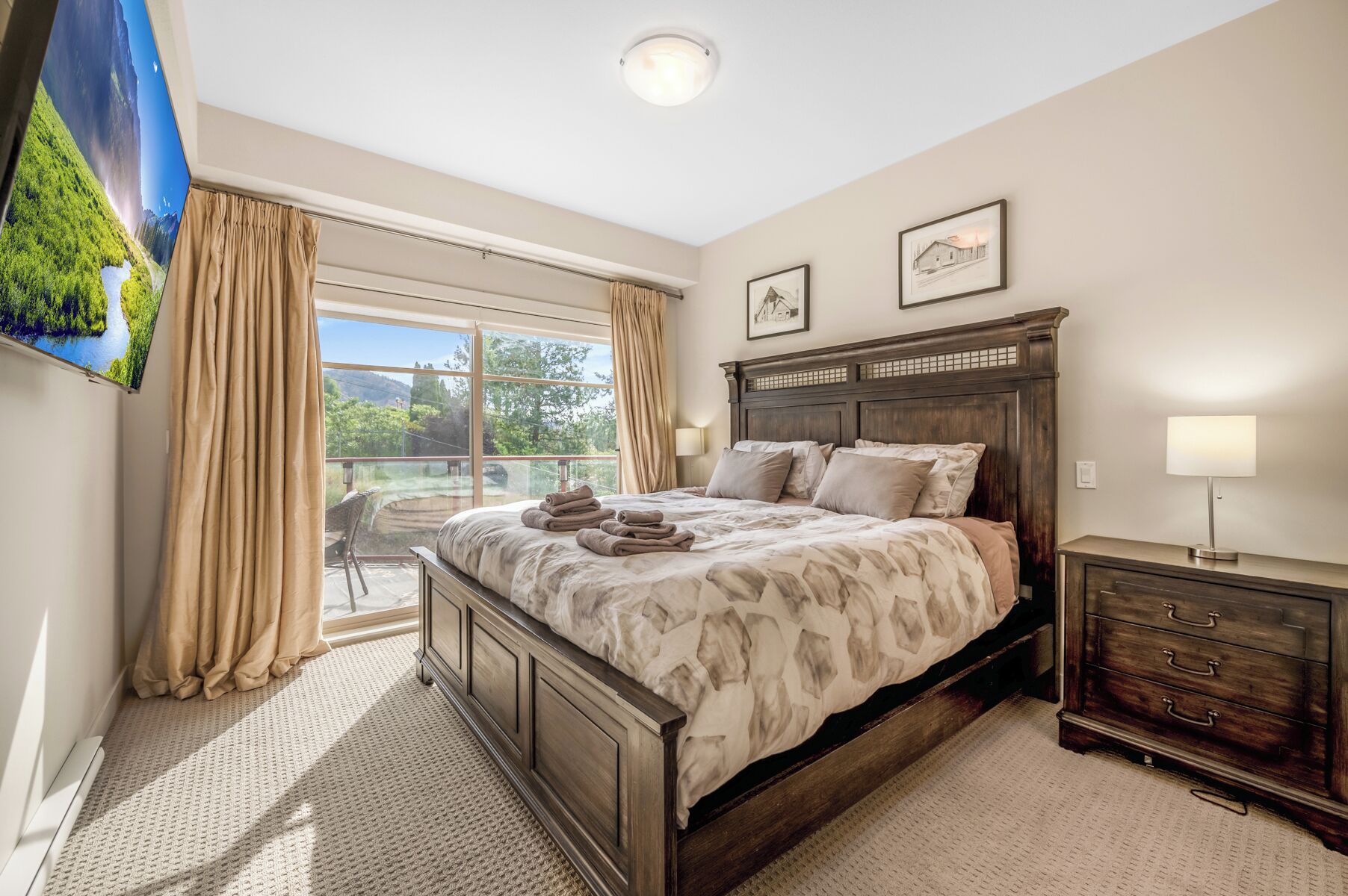 Une chambre avec un grand lit, une commode, une chaise et une vue sur un paysage montagneux.